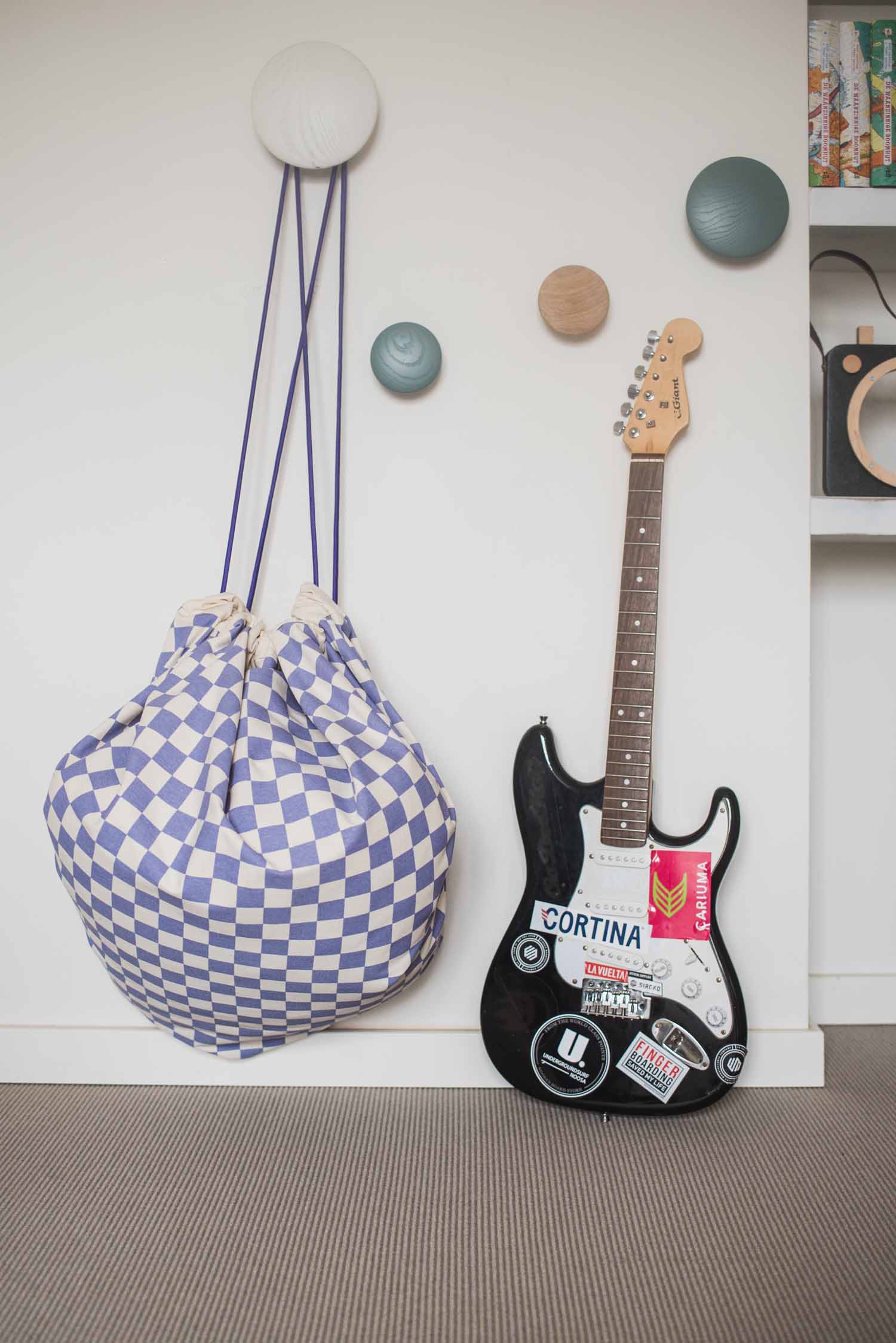 vichy purple storage bag, hanging on coat rack next to guitar