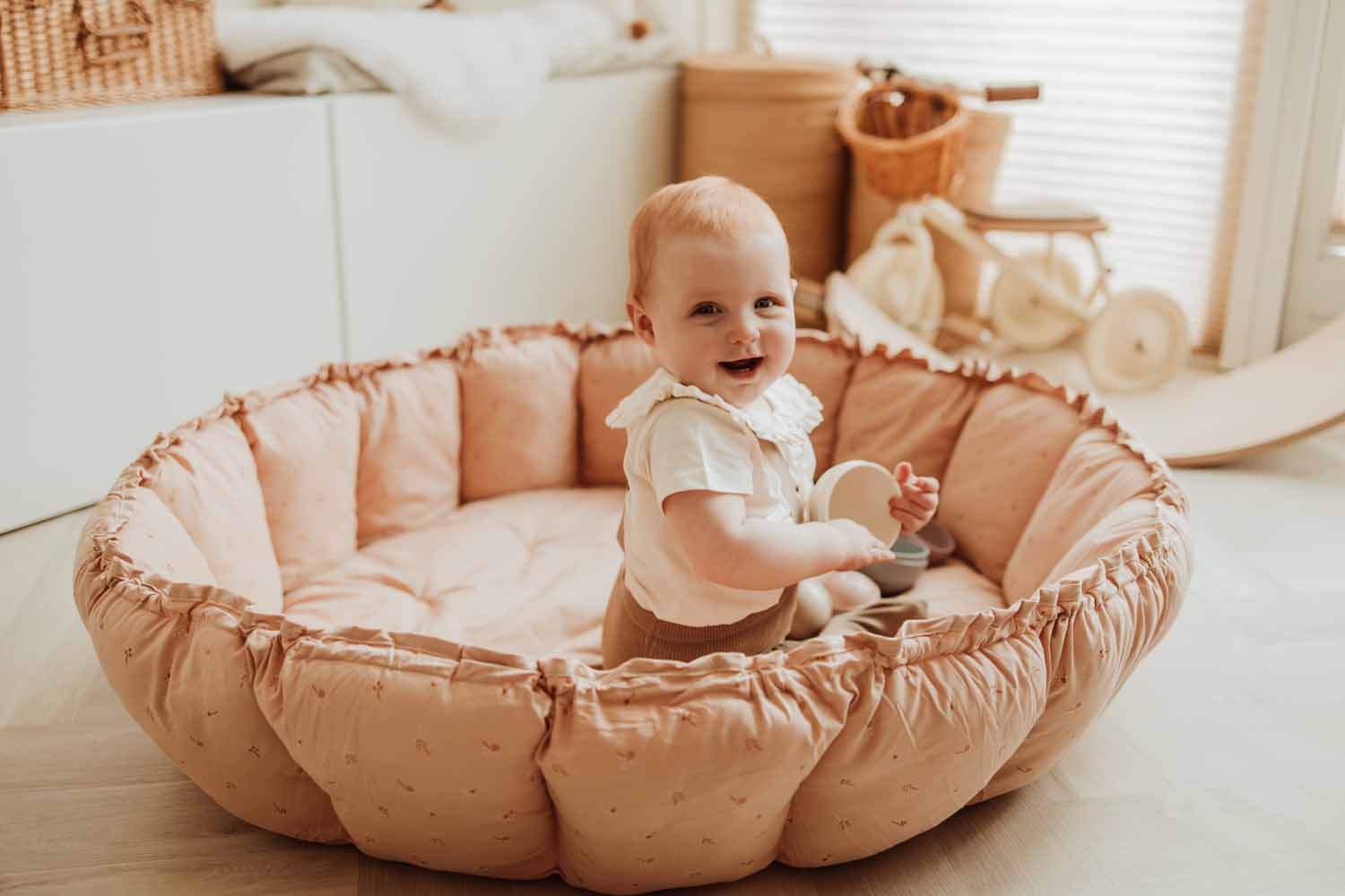 Bloom fleuri organic babymat, baby playing and laughing in crib in kidsroom