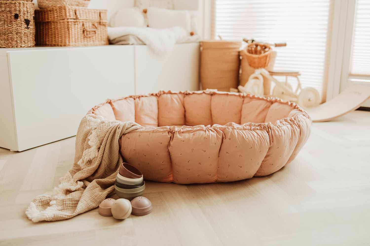 Bloom fleuri organic babymat, raised edges, mat on floor in kidsroom next to baskets and toddler bicycle