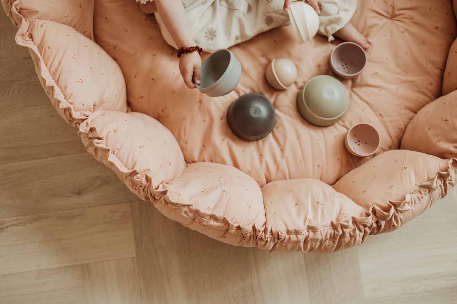 Bloom fleuri organic babymat, raised edges, child playing with toys on mat with raised edges