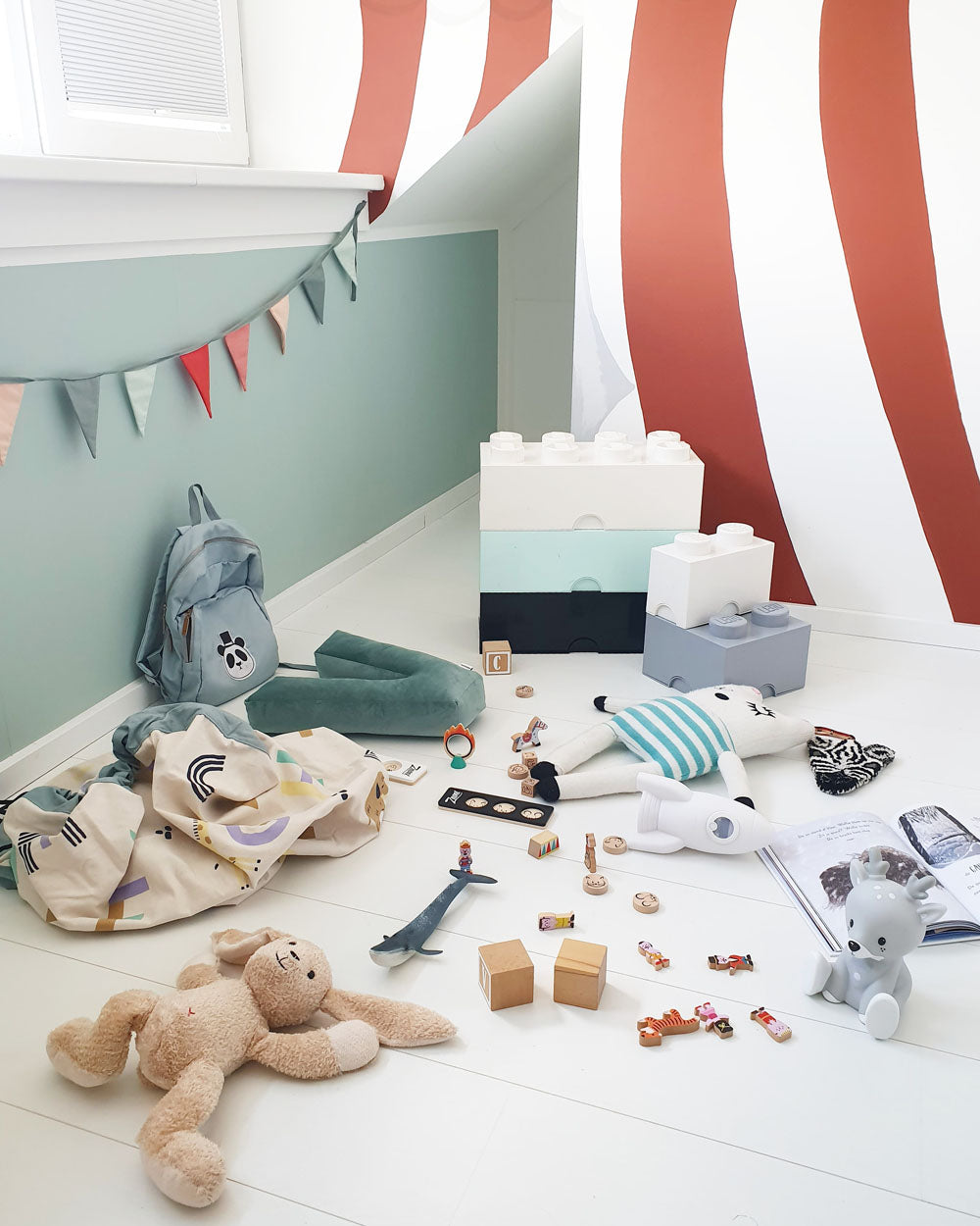 veggie numbers storage bag, on floor in kidsroom, painted circus tent on wall, flags, lots of toys and cuddles on floor