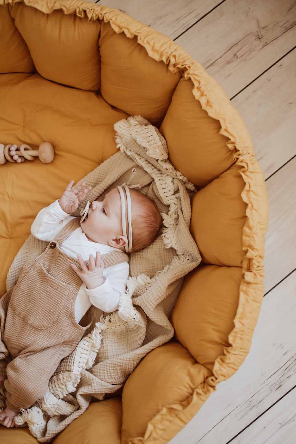 Bloom mustard organic babymat, little baby sleeping on blanket on mat