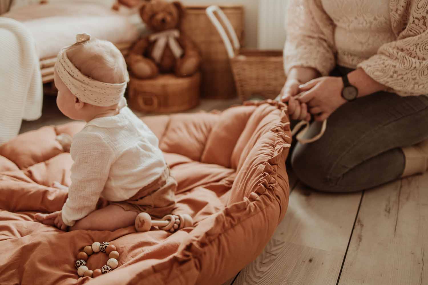 Bloom tawny brown organic babymat, child sitting on mat, person pulling the rope to raise the edges