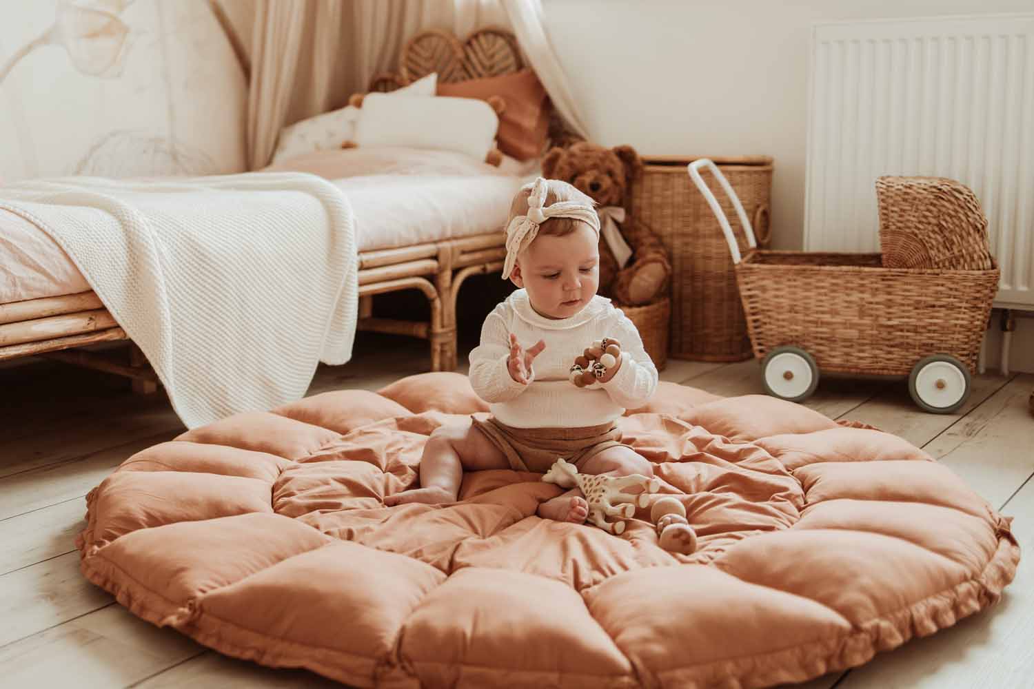 Bloom tawny brown organic babymat, open on floor, child sitting on mat playing, kidsroom, bed and baby carriage
