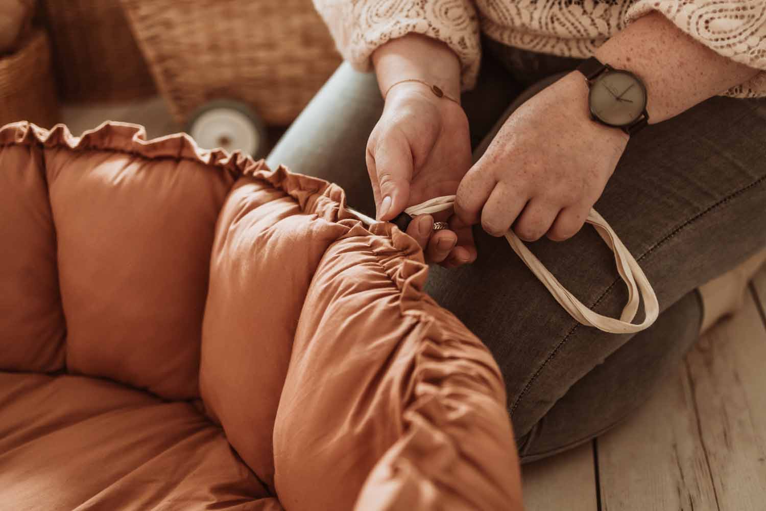Bloom tawny brown organic babymat, detail picture of person who is pulling the rope to raise the edges