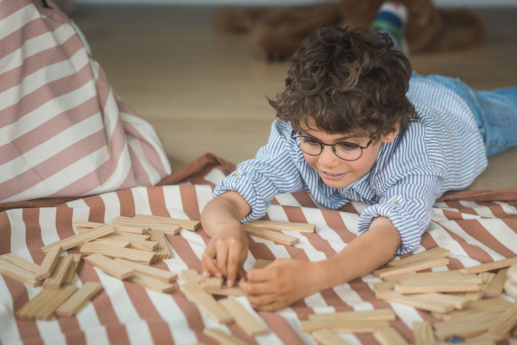 Stripes brown toy storage bag and play mat, child playing with wooden blocks