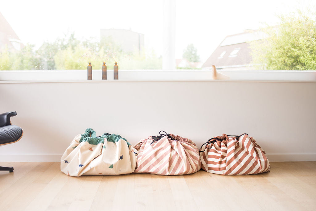 Stripes Pink New toy storage bag, on floor in livingroom next to Dino bag and Stripes Brown bag