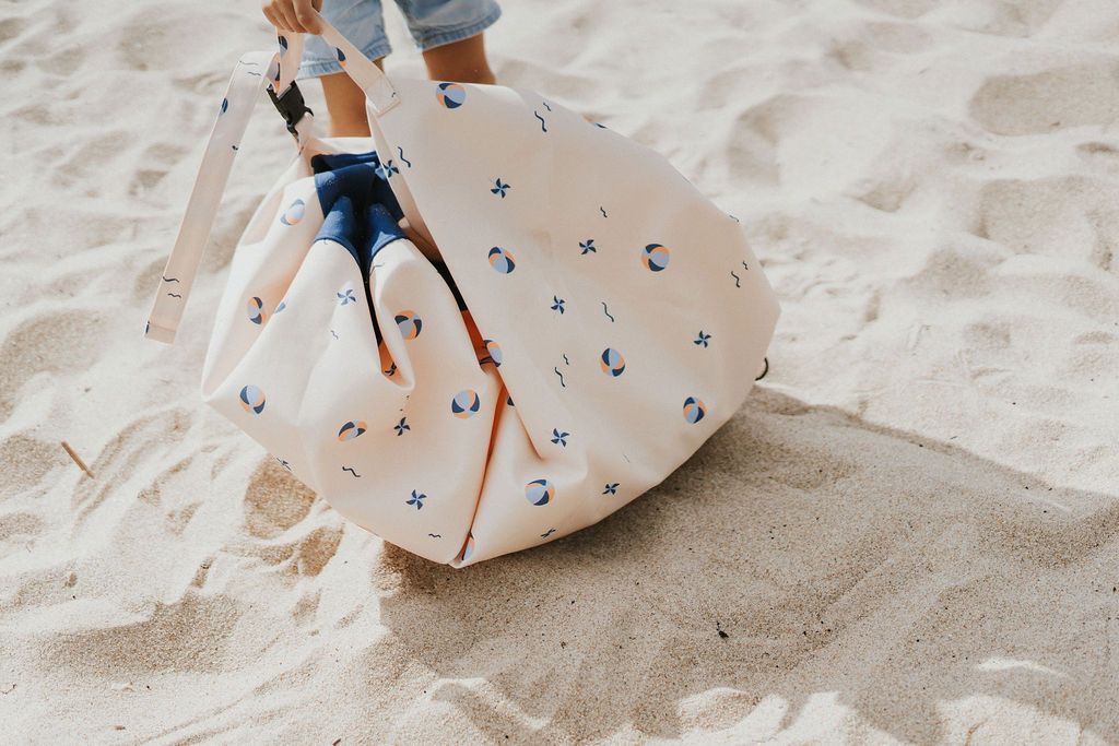 outdoor balloon storage bag and play mat, child carrying the bag, walking in the sand