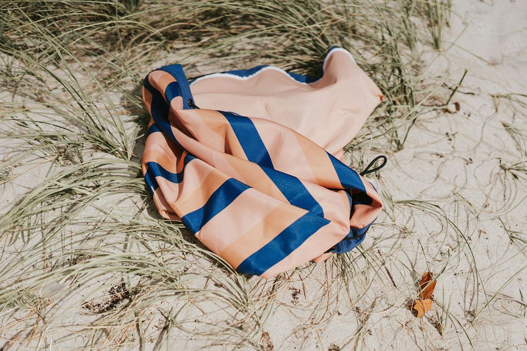 Play&Go outdoor storage bag and play mat, mokka stripes, lying in the dunes