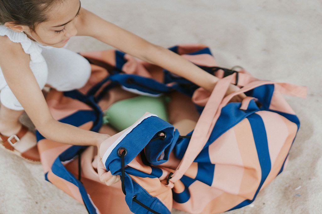 mokka stripes outdoor storage bag, child opening the bag, looking for toys, playing in the sand