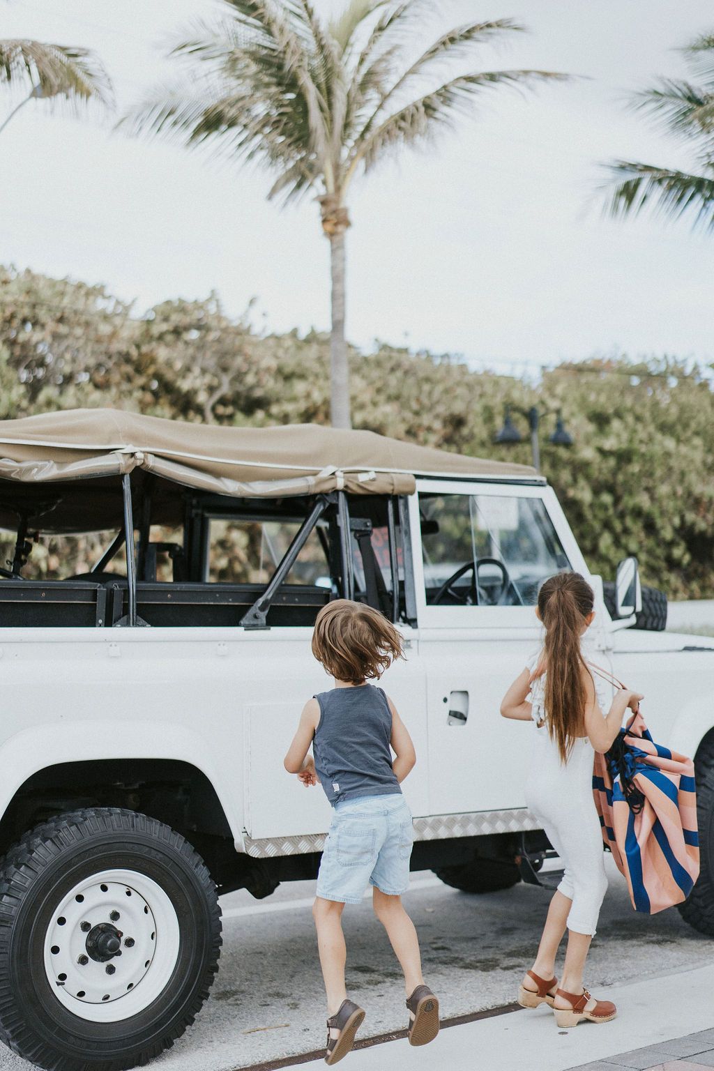 mokka stripes outdoor beach bag, children carrying the bag while walking to a white jeep