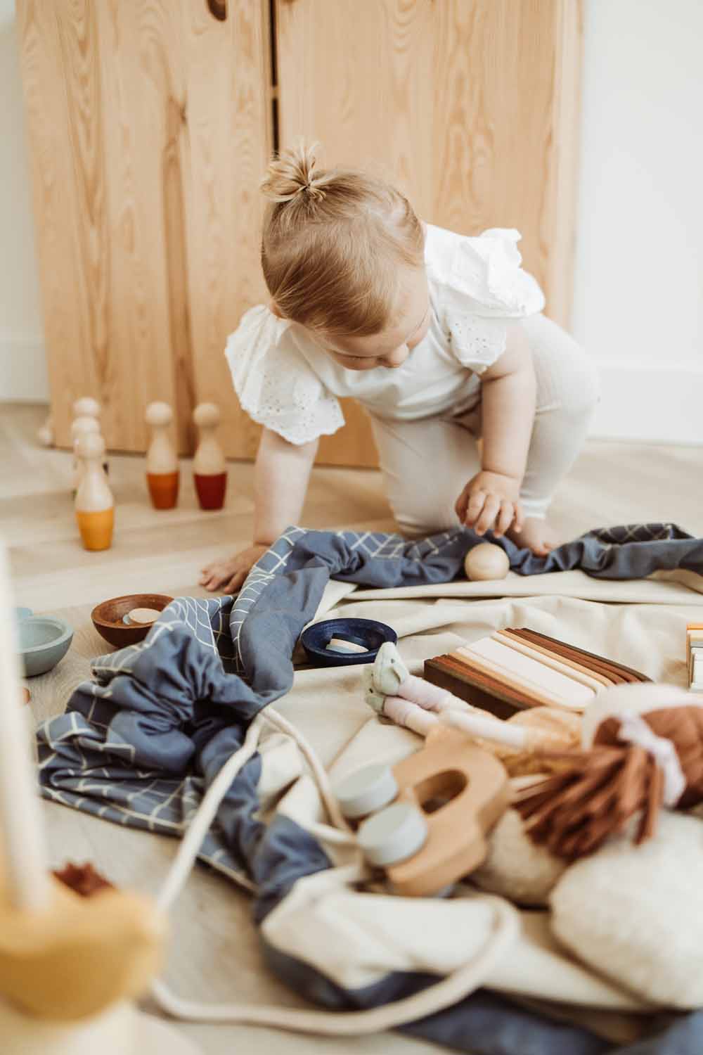organic storage bag grid blue, open bag on floor, filled with toys, child playing