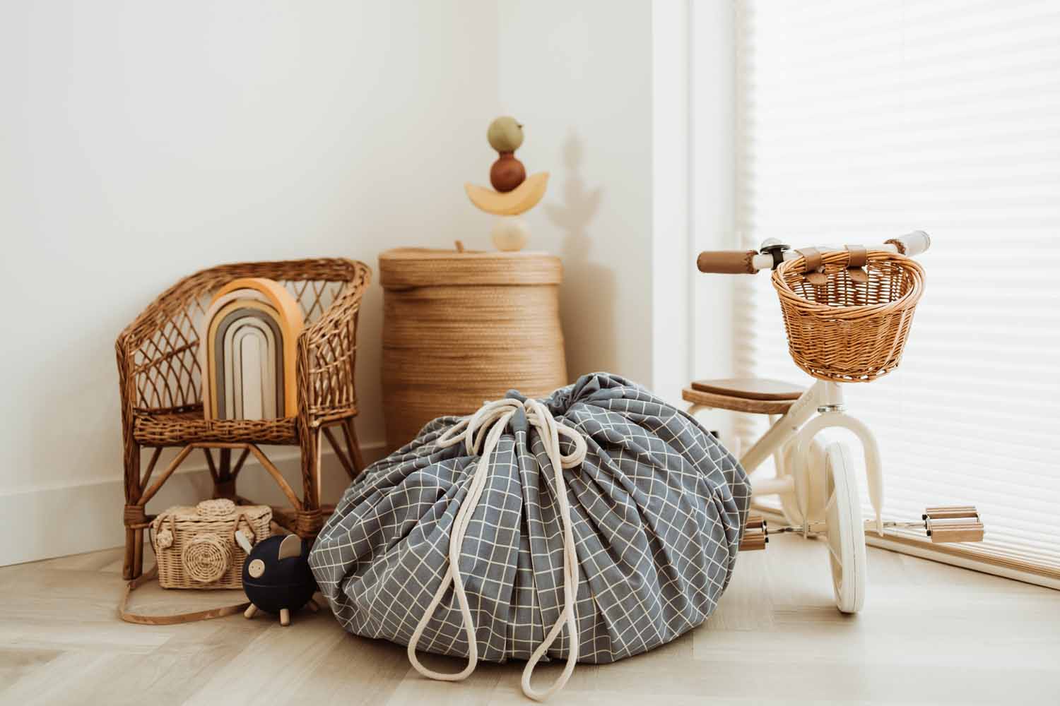 closed organic storage bag grid blue, on floor in kidsroom, tricycle, wicker chair