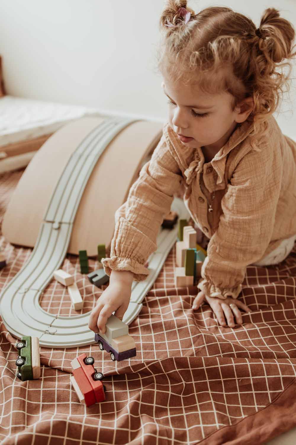 organic grid brown storage bag, child playing with wooden cars on road on open bag 