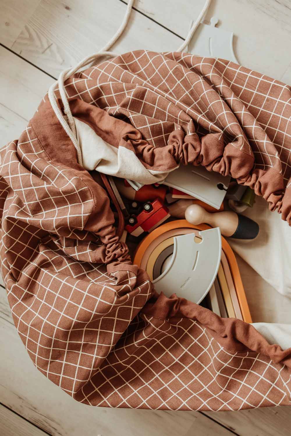 organic grid brown storage bag, filled with toys