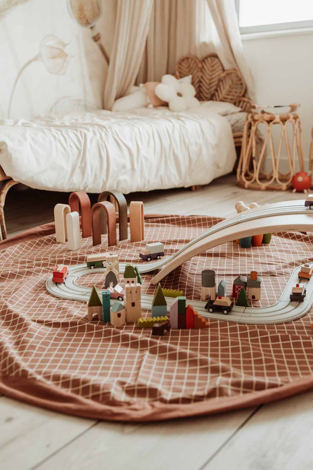 open organic grid brown playmat, on floor in kidsroom, lots of wooden toys, cosy bed in corner