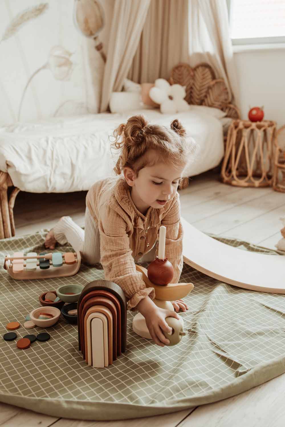 open organic storage bag grid green, on floor in kidsroom, child playing on the mat, next to bed