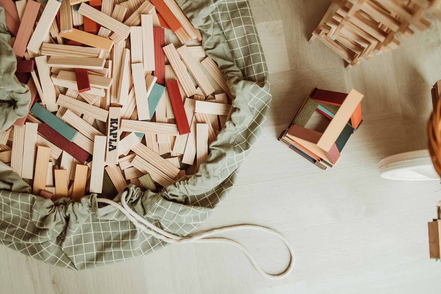 organic storage bag grid green, filled with wooden blocks