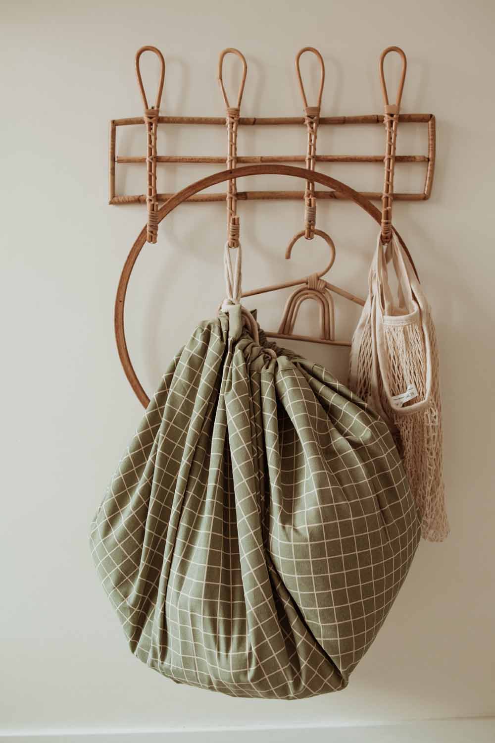 closed organic storage bag grid green, hanging on coat rack on wall