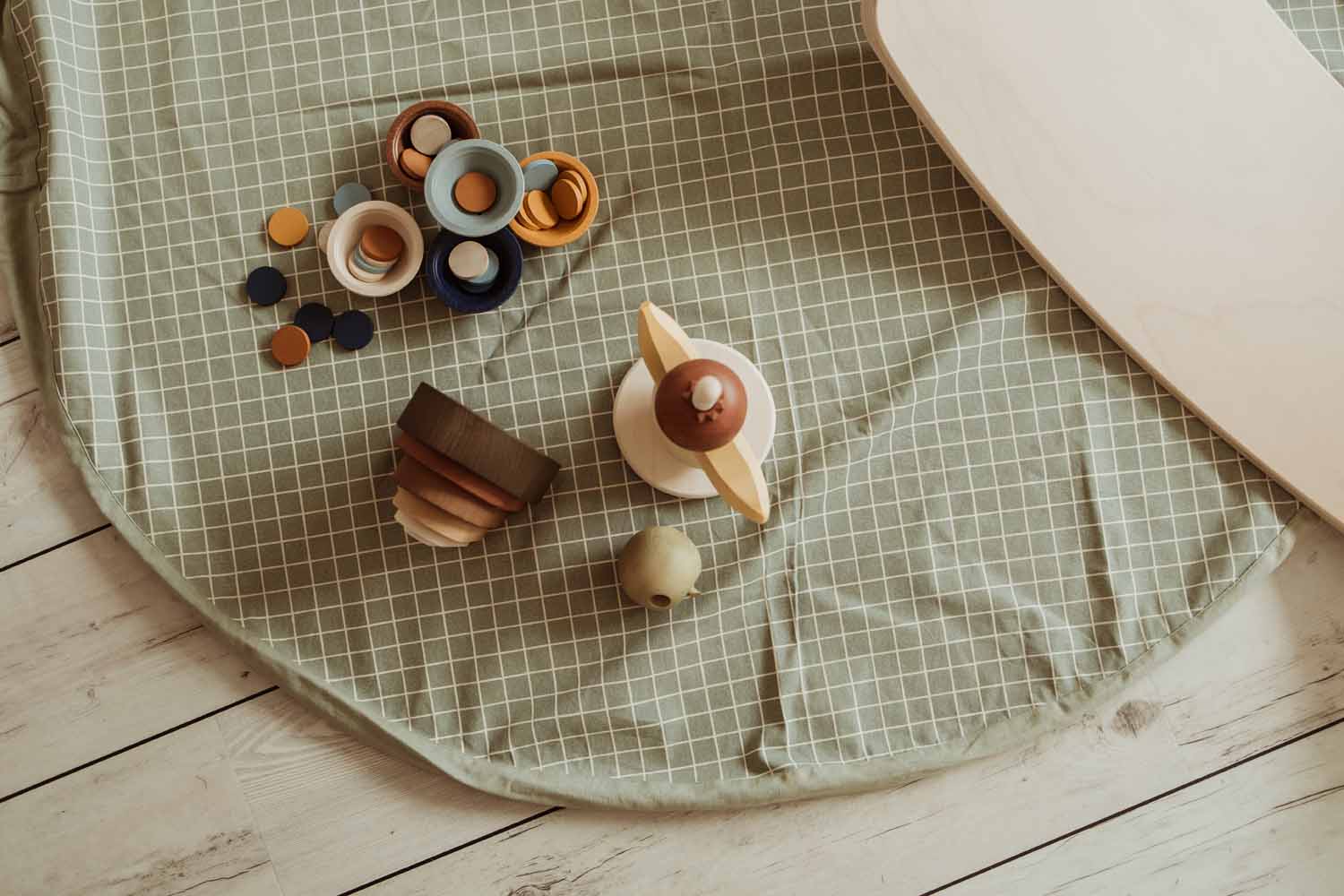 open organic grid green storage bag, on floor with wooden toys