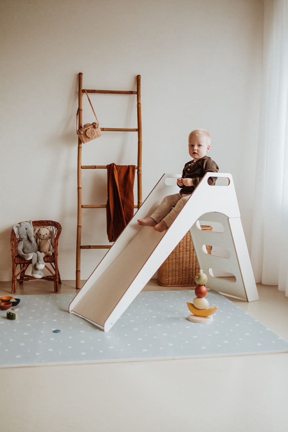 icons puzzlemat on floor, slide with child on the mat in kidsroom