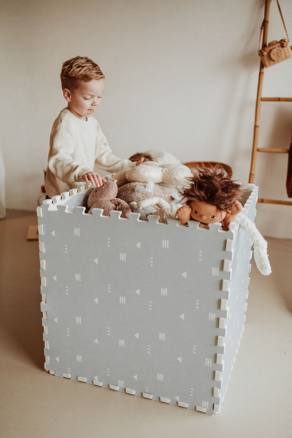 box made of icons puzzlemat, child putting cuddles into the box