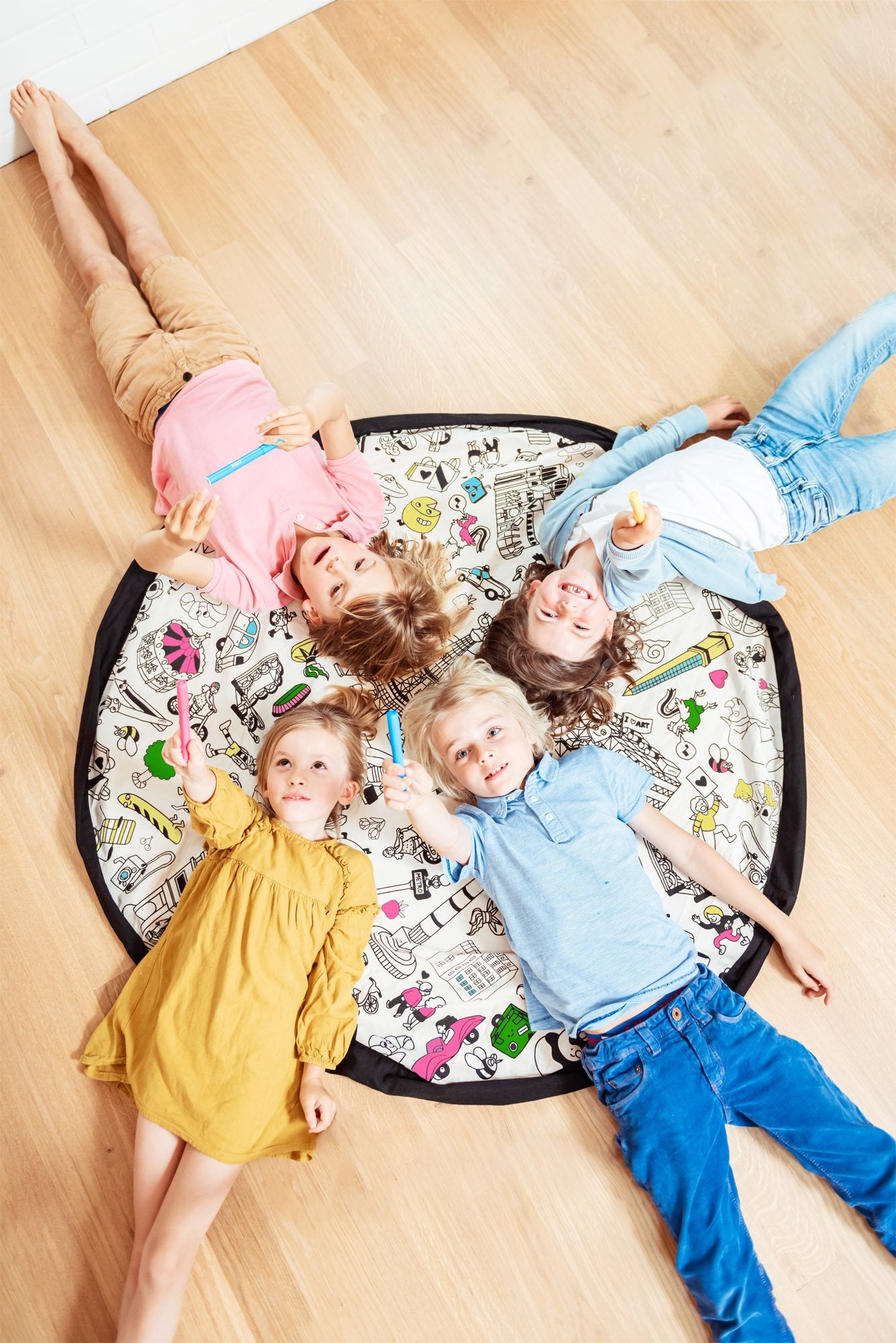 Play&Go storage bag and play mat, lots of fresh colors, 4 children lying on the mat