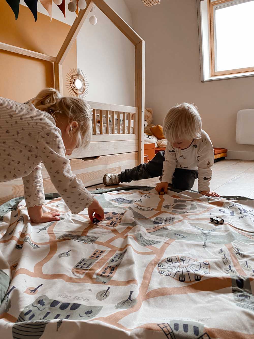 stylish designed Paris Map toy storage bag, children playing on open mat, in kidsroom with wooden bed