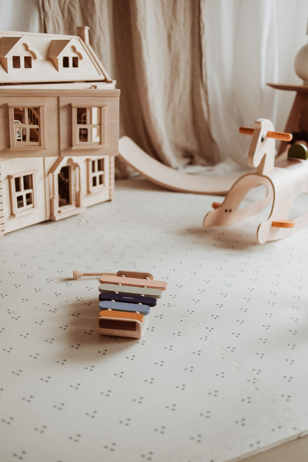 dots puzzlemat lying on floor in kidsroom, victorian play house, rocking horse slide and xylophone