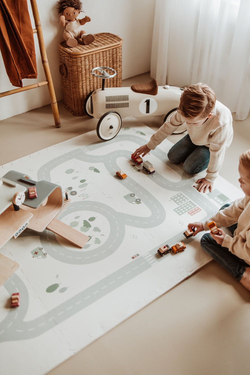 children playing with wooden toys and garage on roadmap puzzlemat in kidsroom